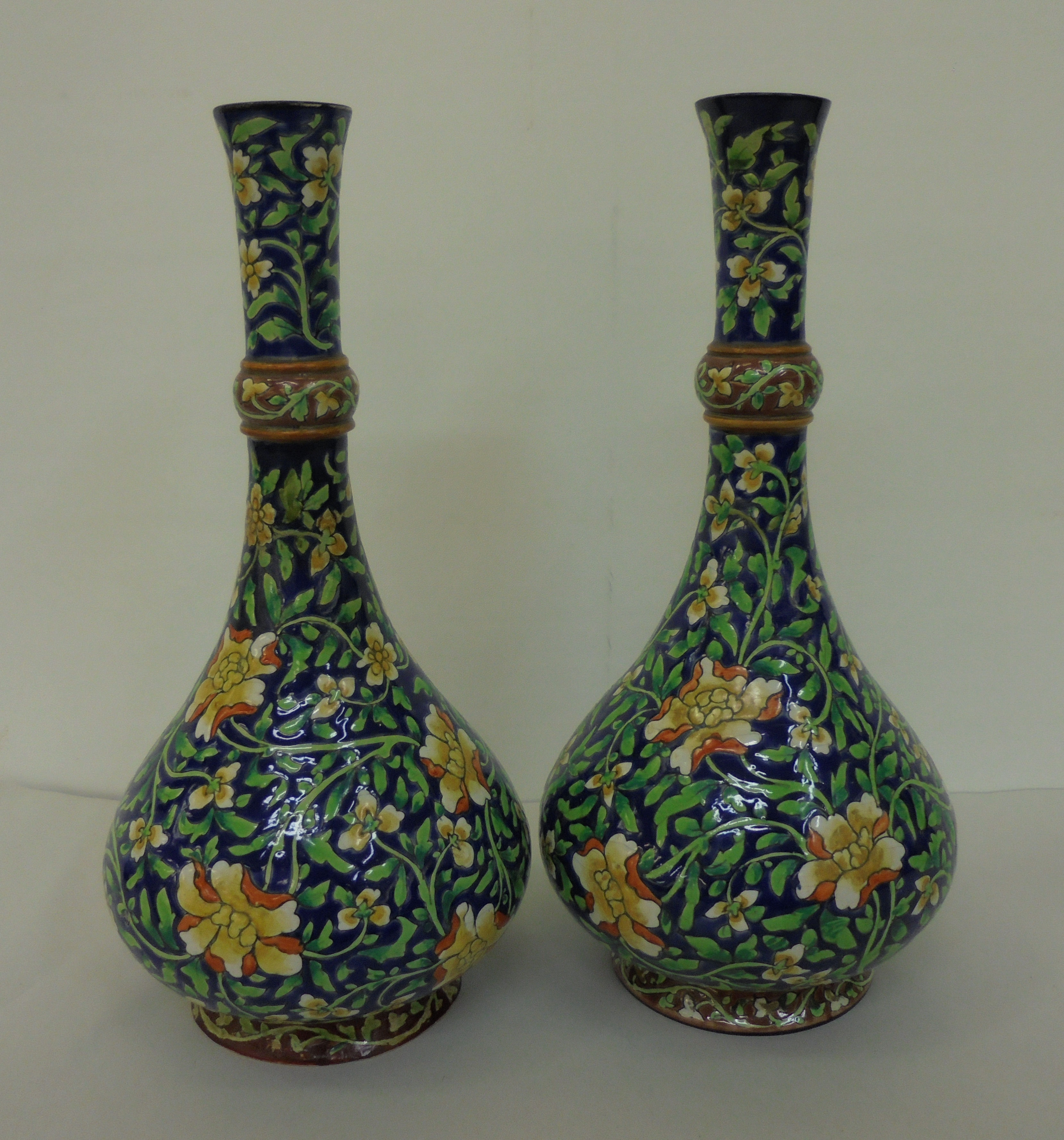 A pair of British Art pottery Arts & Crafts faience vases, decorated in colours with scrolled