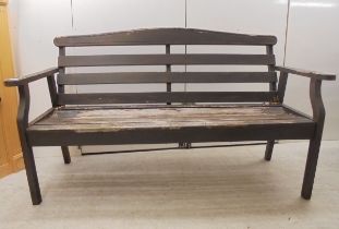 A weathered teak two person open arm bench, raised on square legs  61"w