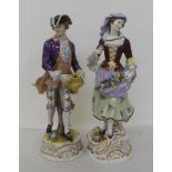 A pair of 20thC Continental porcelain figures, he wearing a tricorn hat and frockcoat, she with