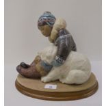 A Lladro matt finished porcelain group, an Inuit and polar bears  9"h on a fabric covered oval