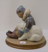 A Lladro matt finished porcelain group, an Inuit and polar bears  9"h on a fabric covered oval