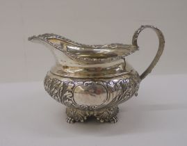 A Georgian silver milk jug, cast with floral motifs  marks rubbed