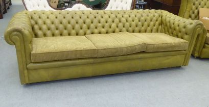 A modern three person Chesterfield settee, part button upholstered in green simulated hide, on