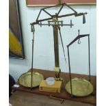 An early 20thC Baird & Tatlock lacquered brass chemical balance with twin pans, on a height