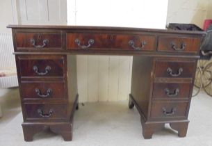 A modern mahogany nine drawer twin pedestal desk, raised on bracket feet  31"h  47"w