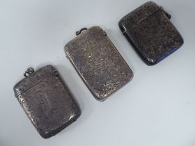 Three similar late Victorian silver vesta cases of rectangular design with hinged caps,