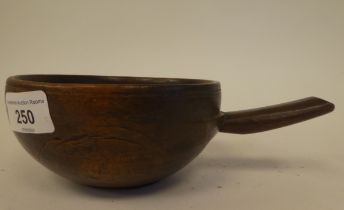 An early 19thC carved and turned beechwood one piece food bowl with a single handle  5.5"dia