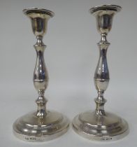 A pair of silver candlesticks with vase shape sockets and detachable, flared sconces, elevated on