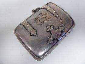An Edwardian silver vesta case, fashioned as a decoratively bound book with a hinged cap, strike