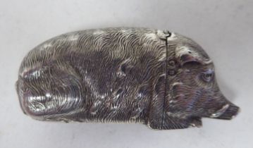 A late Victorian silver novelty vesta case, fashioned as a recumbent wild boar with a hinged cap, on