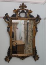A copy of a 19thC carved, gilded and ebonised, Continental overmantel mirror, the plate set in an