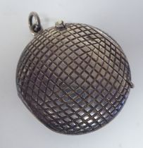 An Edwardian silver novelty vesta case, fashioned as a golf ball with a hinged cap, strike plate and