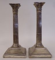 A pair of late Victorian loaded silver candlesticks with bead bordered decoration, each having a