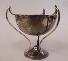 A silver triple handled trophy cup, elevated on three swept supports and a domed circular base