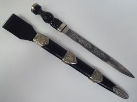 A Pipers dirk with white metal mounts, the traditionally styled handgrip with studwork ornament