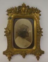 A late Victorian ornately cast, lacquered brass glazed picture frame, displaying a monochrome head