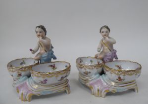 A pair of 20thC Dresden porcelain double salt cellars, featuring a cherubic figure with floral