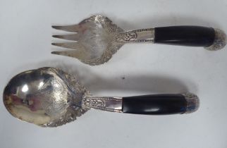 A pair of Malaysian silver coloured metal salad servers, decorated with dragons and other