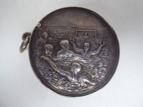 An Edwardian silver vesta case of disk design with a hinged cap and suspension ring, embossed with a