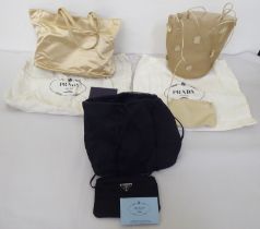 Three Prada fabric handbags, viz. a Raso Gold 1998 with dust cover, one in cream coloured net with