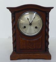 A 1930s oak cased mantel clock; the 8 day movement faced by an Arabic dial  11"h