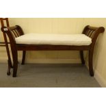 A 19thC style mahogany framed window seat with low, scrolled ends and a solid base and cream