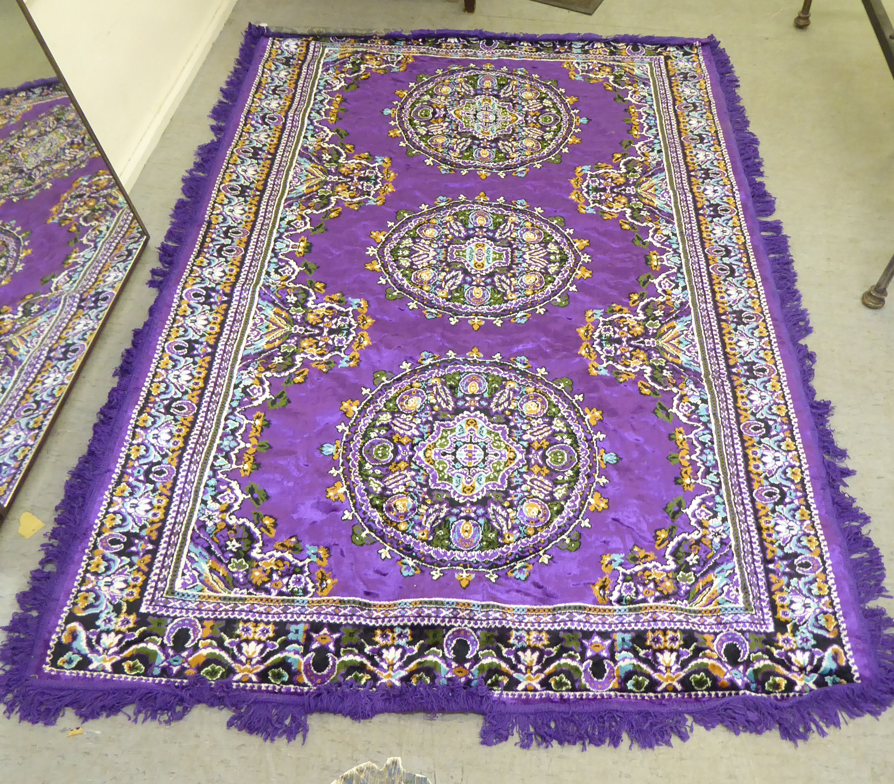 A Persian design rug, decorated with floral motifs, on a purple ground  86" x 56"