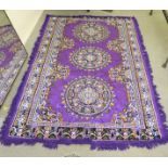 A Persian design rug, decorated with floral motifs, on a purple ground  86" x 56"