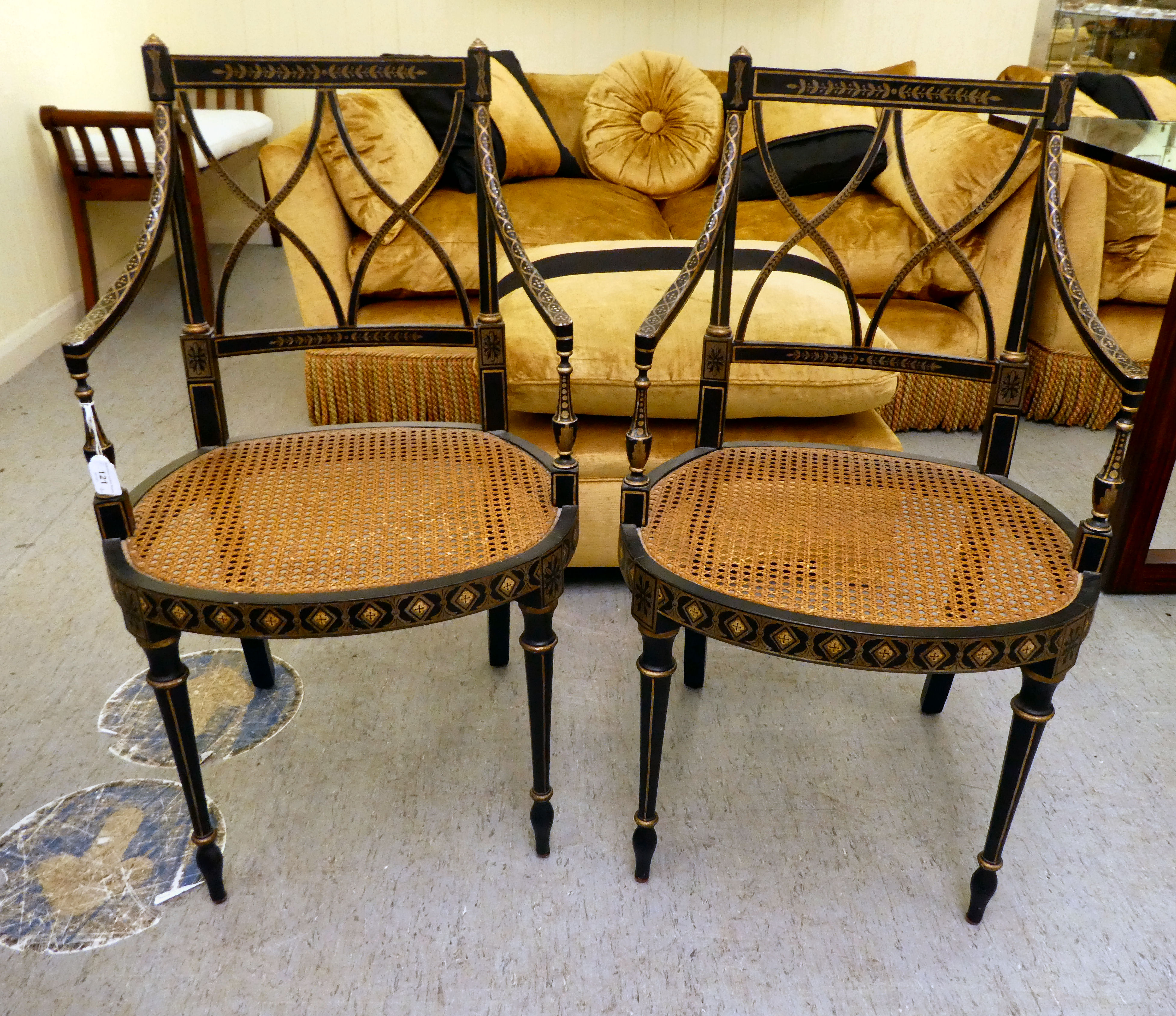 A pair of early 19thC style black painted and gilded beech framed chairs, each having a curved