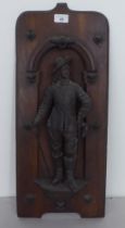 A mid 20thC stained beech wall plaque, surmounted by a spelter musketeer figure  23"h overall