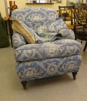 A Victorian style bedroom armchair with printed blue and white patterned upholstered and a cushioned