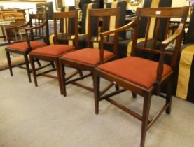 A set of four early 19thC mahogany framed dining chairs, each with a slatted black and drop-in seat,