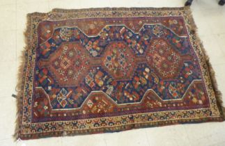 A Persian rug, decorated with triple gul motifs, on a red and blue ground  45" x 63"
