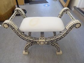 A modern Middle Eastern inspired Savonarola style stool, decorated in black and white with floral