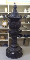 A Japanese bronze finished, metal temple censer with a pagoda top, over a pierced bowl, on a