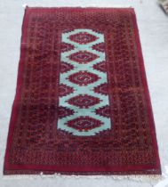A Persian rug, decorated with a central pole medallion, on a red ground  37" x 56"