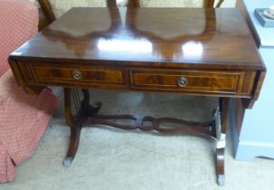 A modern reproduction of a Georgian string inlaid mahogany sofa table, raised on lyre shaped ends,