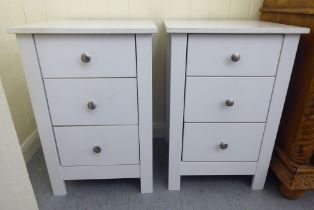 A pair of modern white painted three drawer bedside chests, raised on square legs  24"h  16"w