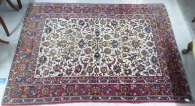 A Persian rug, decorated with flora and foliate designs, on a multi-coloured ground  58" x 84"