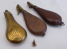 Two early 20thC brown hide shot flasks; and a contemporary brass example