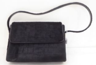 A Gucci black fur covered handbag with a dust cover