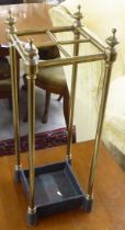 An early 20thC lacquered brass four division stickstand with a cast iron tray  24"h
