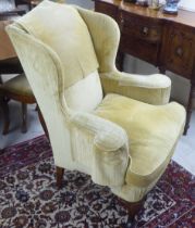 An early 20thC Georgian style and later fabric upholstered horseshoe shape wingback, enclosed