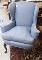 An early 20thC Georgian style and later fabric upholstered horseshoe shape, wingback enclosed