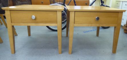 A pair of modern light oak single drawer lamp tables, raised on square, tapered legs  20"h  24"w