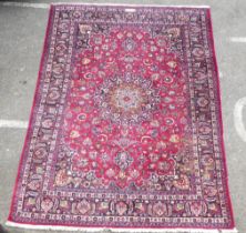 An Iranian rug, decorated with ornate designs, on a red and blue ground  138" x 96"