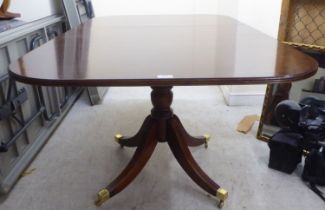 A 20thC reproduction of a Regency string inlaid crossbanded mahogany single pedestal dining table