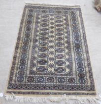 A Bokhara rug, decorated with elephant foot motifs, on a beige and blue ground  60" x 38"