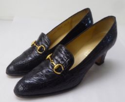 A pair of ladies Gucci crocodile skin effect black leather, low heeled and brass buckled shoes  size