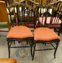 A pair of late Victorian style black lacquered and gilded bedroom chairs, decorated in